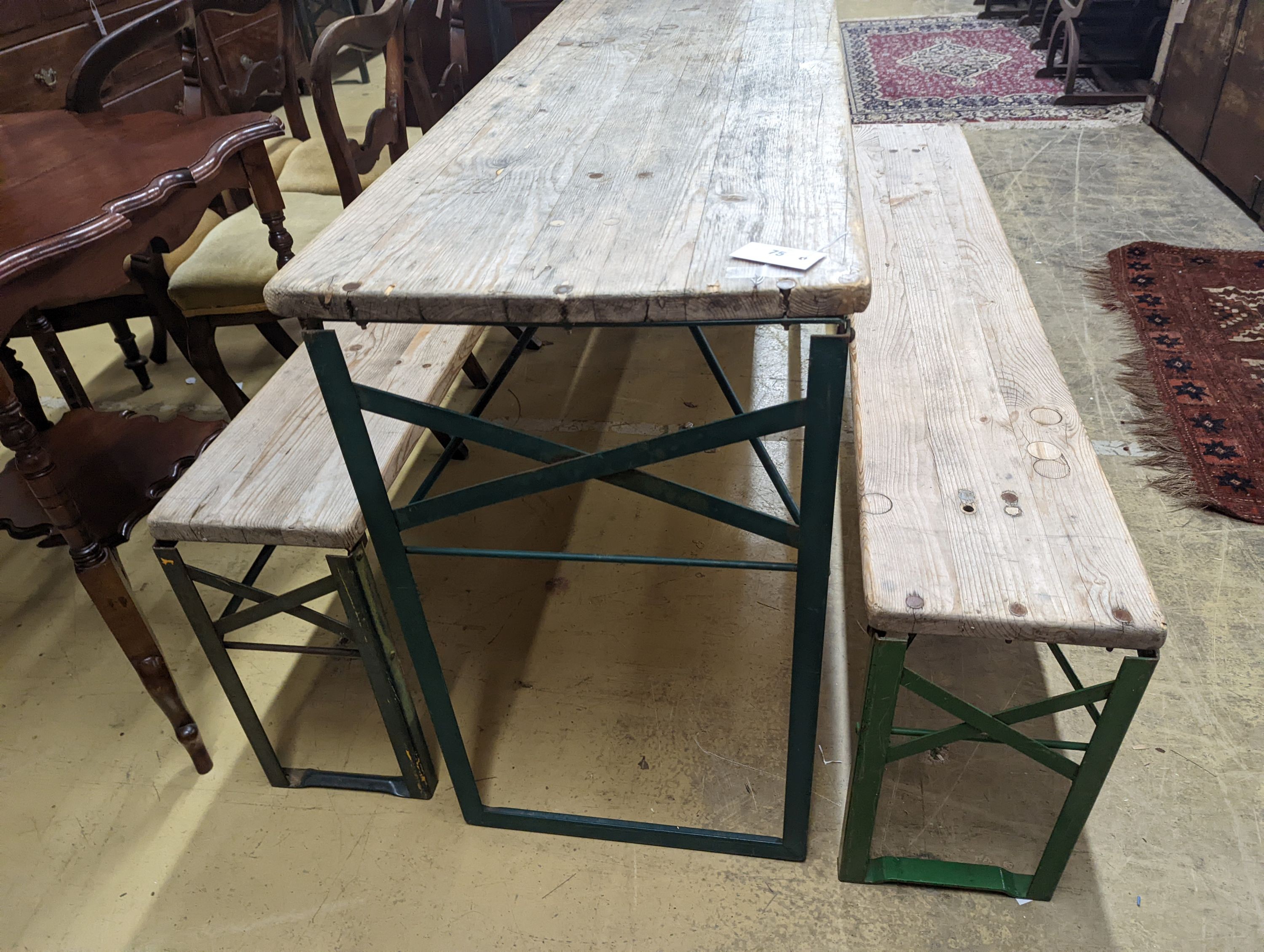 A rectangular pine and painted wrought iron folding garden trestle table, length 150cm, depth 50cm, height 78cm and a pair of matching bench seats